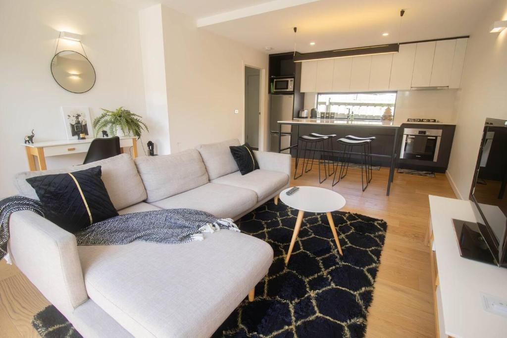 a living room with a white couch and a kitchen at Lakes Edge 4 in Wendouree