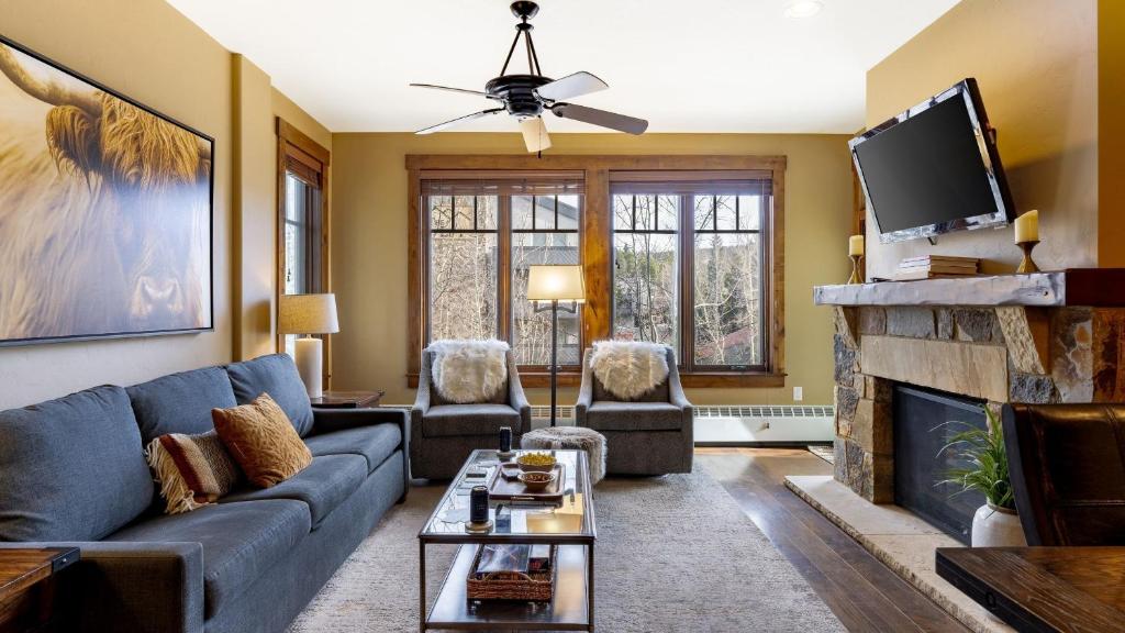 Una sala de estar con un sofá azul y una chimenea. en Steps to Lifts Peak 9 Main Street Balcony Lounge Pool Water House 5204 by AvantStay, en Breckenridge