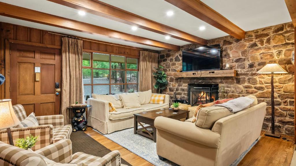 a living room filled with furniture and a stone wall at The Horseshoe Hideaway Lake Harmony Cabin w Hot Tub Game Porch in Lake Harmony