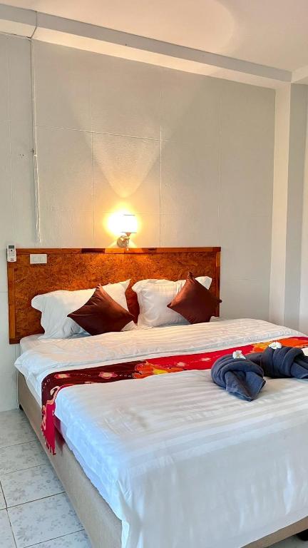 a bedroom with two beds and a light on the wall at Book Lanta House in Ban Ru Yai