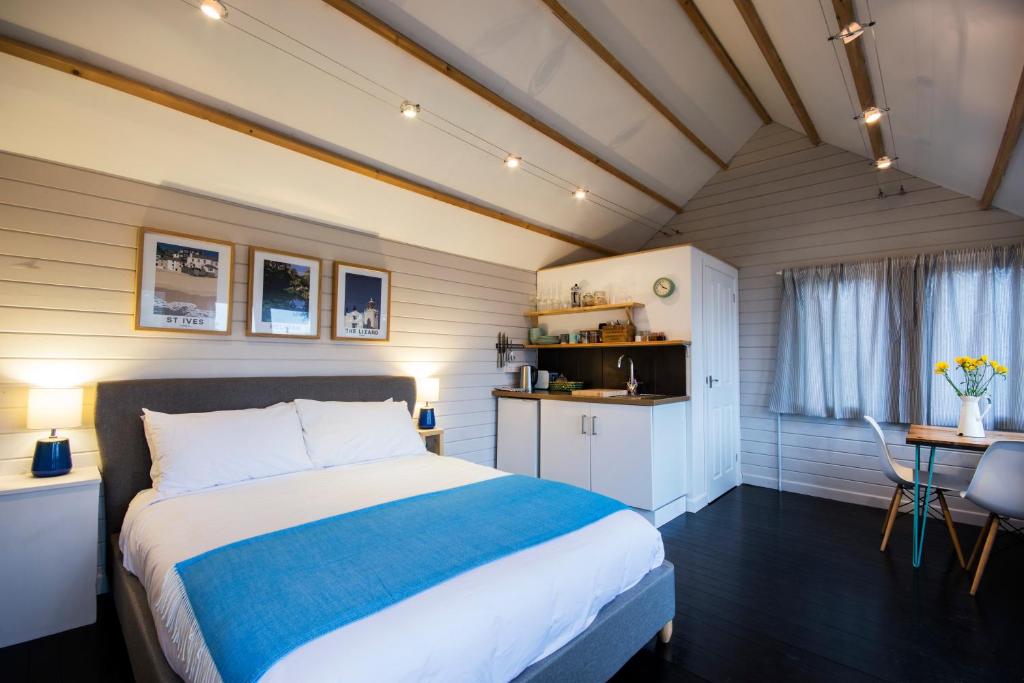 特魯羅的住宿－The cabin，一间卧室配有一张床、一张桌子和一张桌子