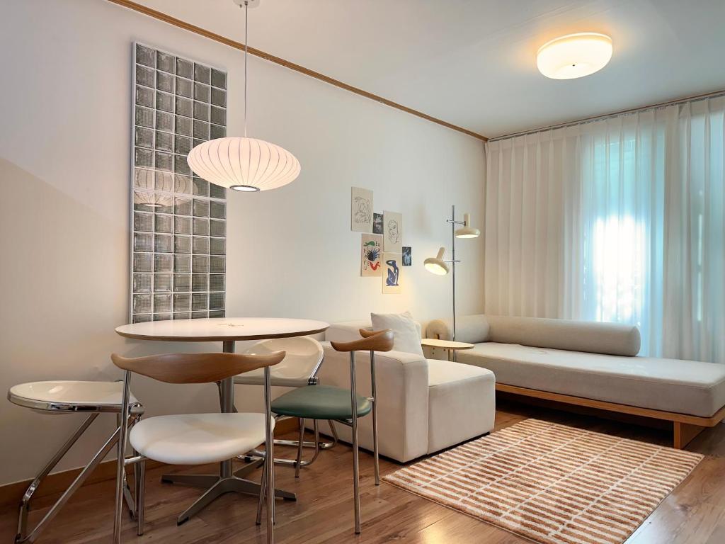 a living room with a couch and a table and chairs at Modern 203 Stay in Seoul