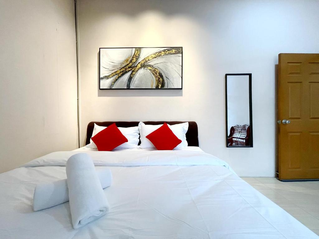 #SS SuperCorner 4Bedroom HomeStay 20PAX EventUse By S&T Homez في سِريمبان: غرفة نوم بسرير ابيض ومخدات حمراء