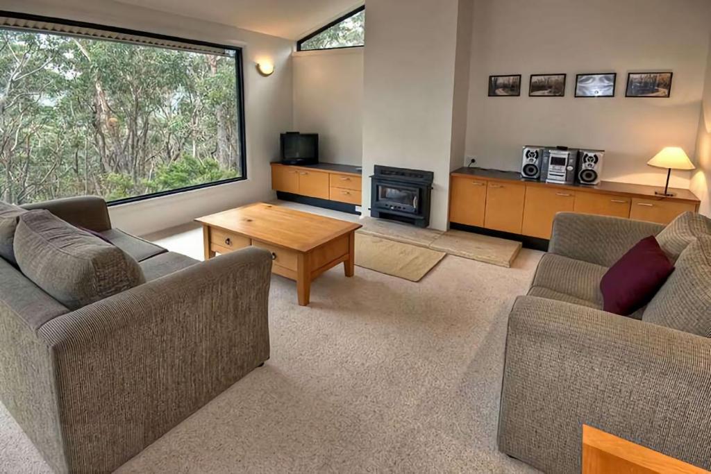a living room with two couches and a table at Delmonte in Medlow Bath
