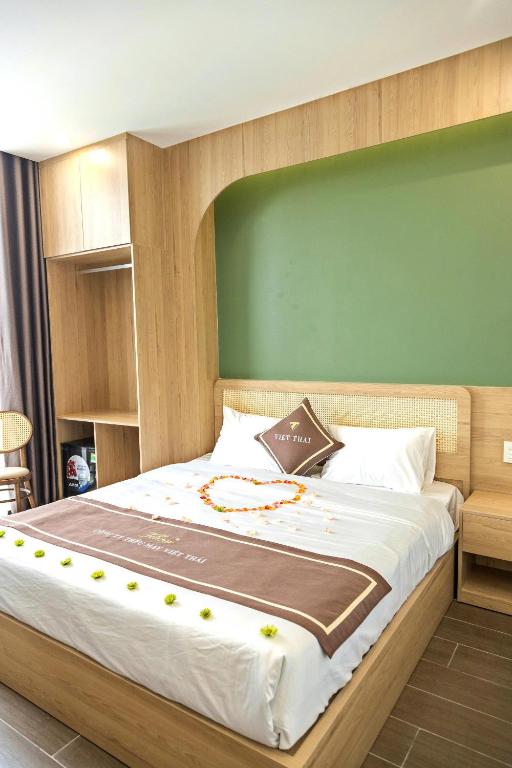 a bedroom with a large bed with a green wall at Hiden An Hotel in Ninh Binh