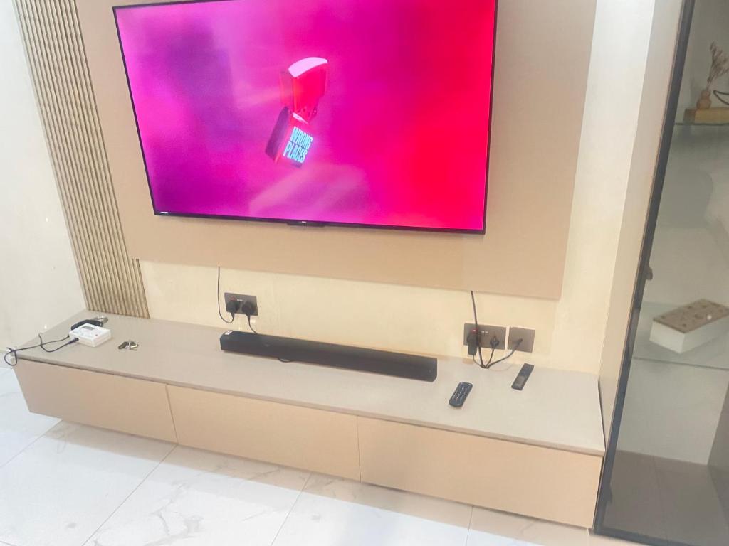 een flatscreen-tv aan een muur in een kamer bij Car hire Africa in Kampala