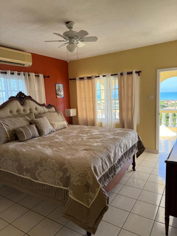 a bedroom with a large bed with orange walls at Superstar Living in Treasure Beach
