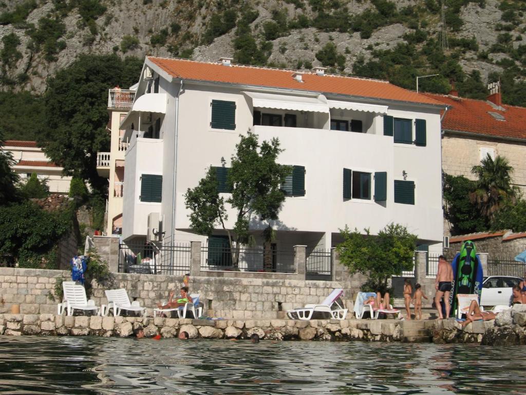 a white house on the shore of a body of water at Villa Iva in Kotor