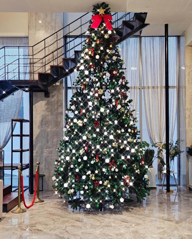 a christmas tree in a room with a staircase at Blanc Hotel & Resort in Yeosu