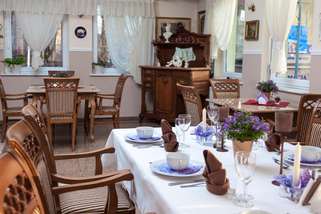 un comedor con mesas y sillas con flores. en Stary Młyn en Żory