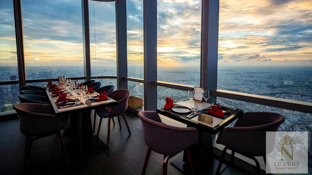 a restaurant with tables and chairs in a room with a view at The Majesty Landmark 81 Residence in Ho Chi Minh City