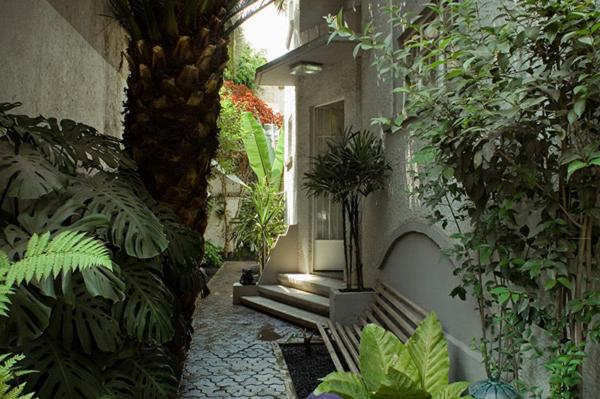 a garden with a bench in a courtyard with plants at Stella Bed & Breakfast in Mexico City