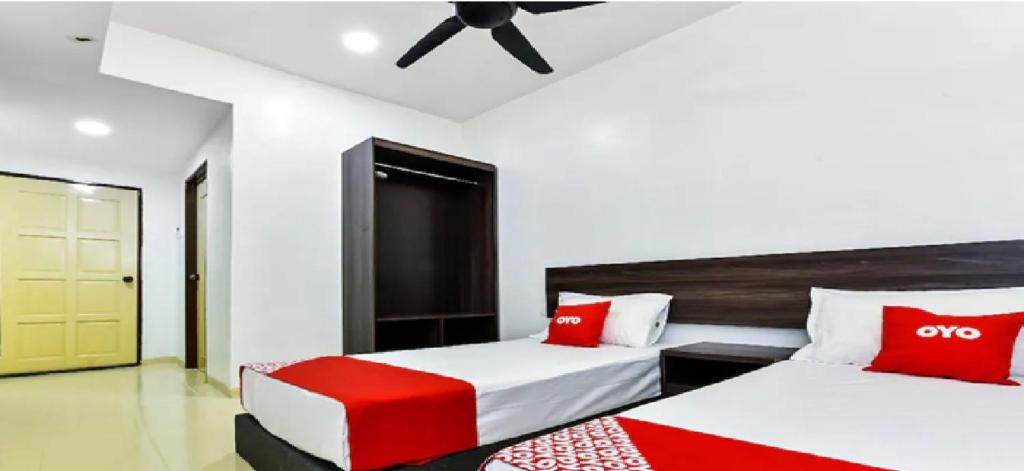 a bedroom with two beds and a ceiling fan at HP Usima Forest Resort Melaka in Ayer Keroh