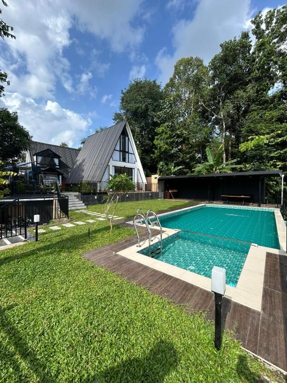 a swimming pool in the yard of a house at Mangalath River View Resorts in Kodanad