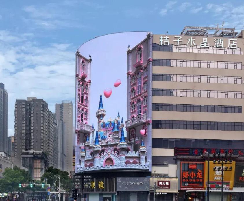 a disney castle in a city with pink balloons at Orange Crystal Hotel Changsha IFS in Changsha