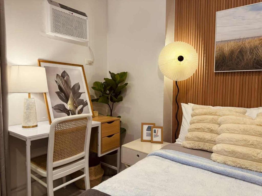 The Modern Nest Condo في مدينة سيبو: غرفة نوم مع سرير ومكتب مع مروحة
