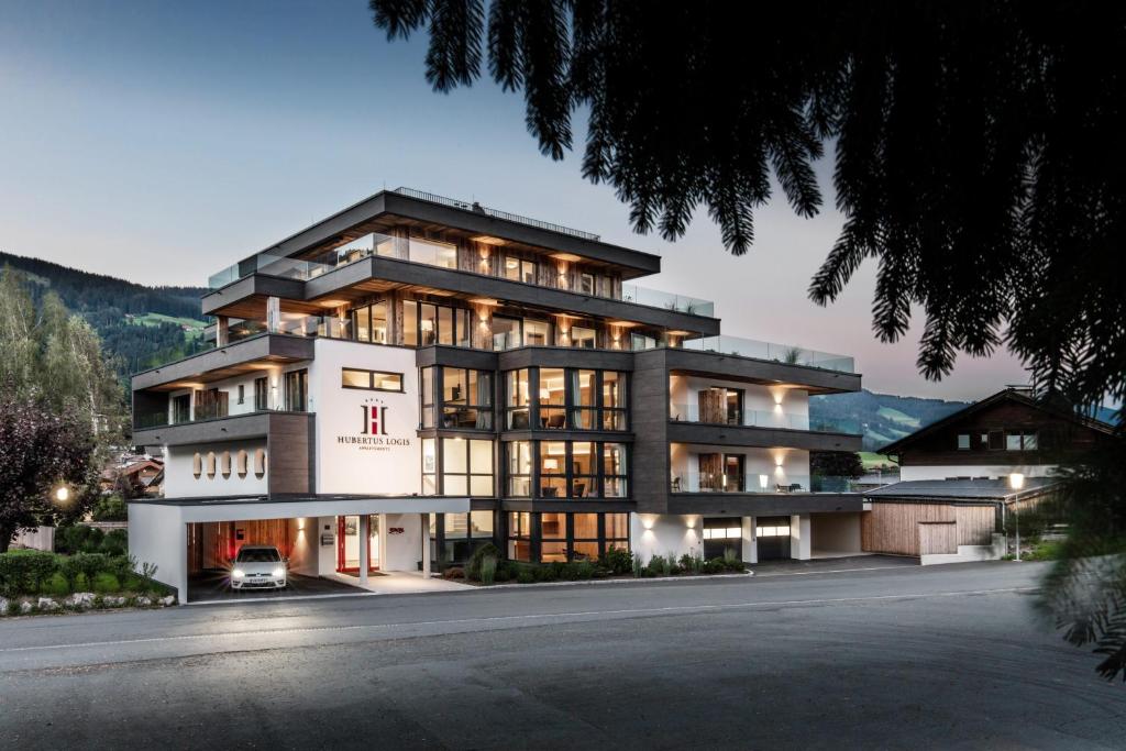 a large building with a car parked in front of it at Hubertus Logis Apartments in Brixen im Thale