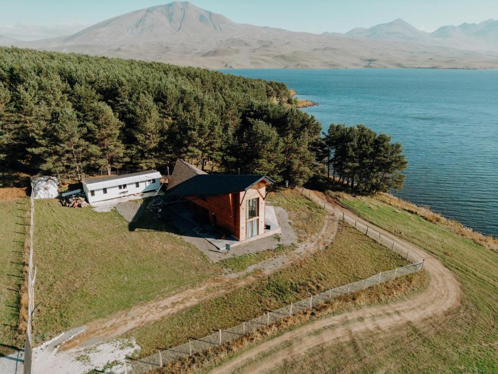 an aerial view of a house on a hill next to the water at Cottage Tabatskuri in Molit'i