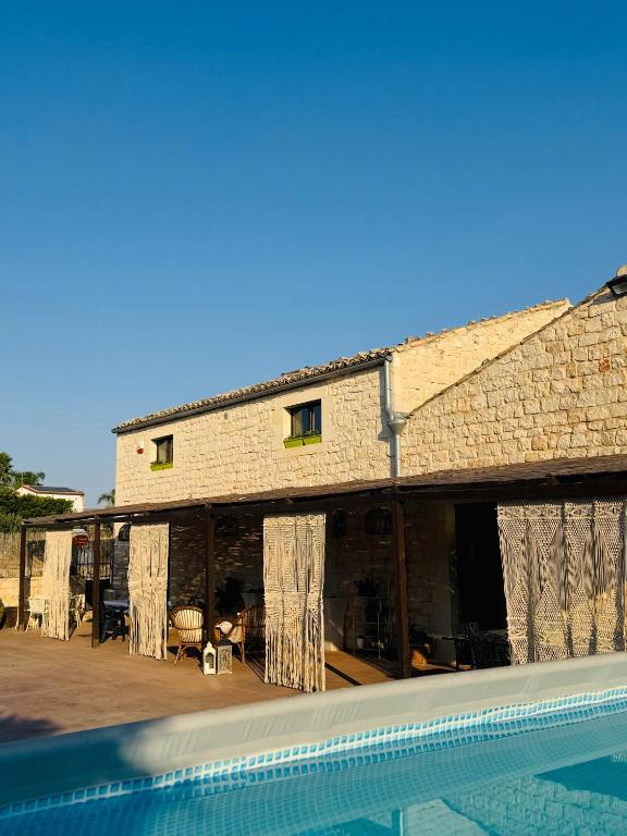 a building with a swimming pool in front of it at Il Casale di Luisa in Modica