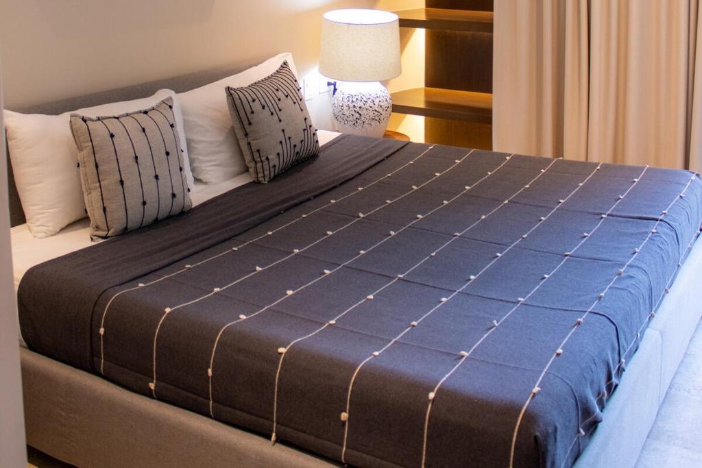 a large bed in a room with a lamp at Peregrina Tulum 202C 1 Bedroom Condo in Tulum