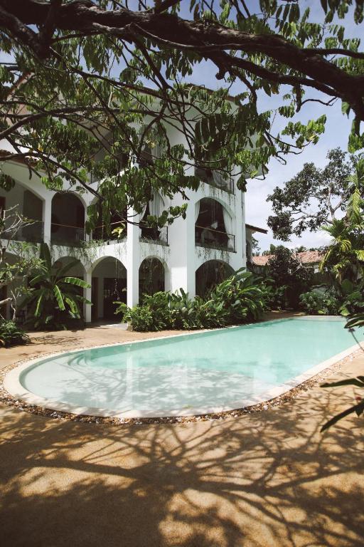 a swimming pool in front of a house at Oura Spirit in Unawatuna