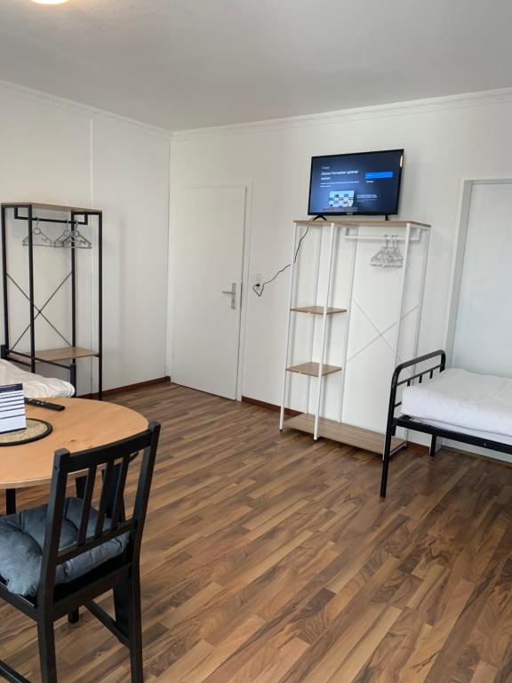 Zimmer mit einem Tisch, einem Stuhl und einem TV in der Unterkunft Villa Porta Westfalica in Porta Westfalica