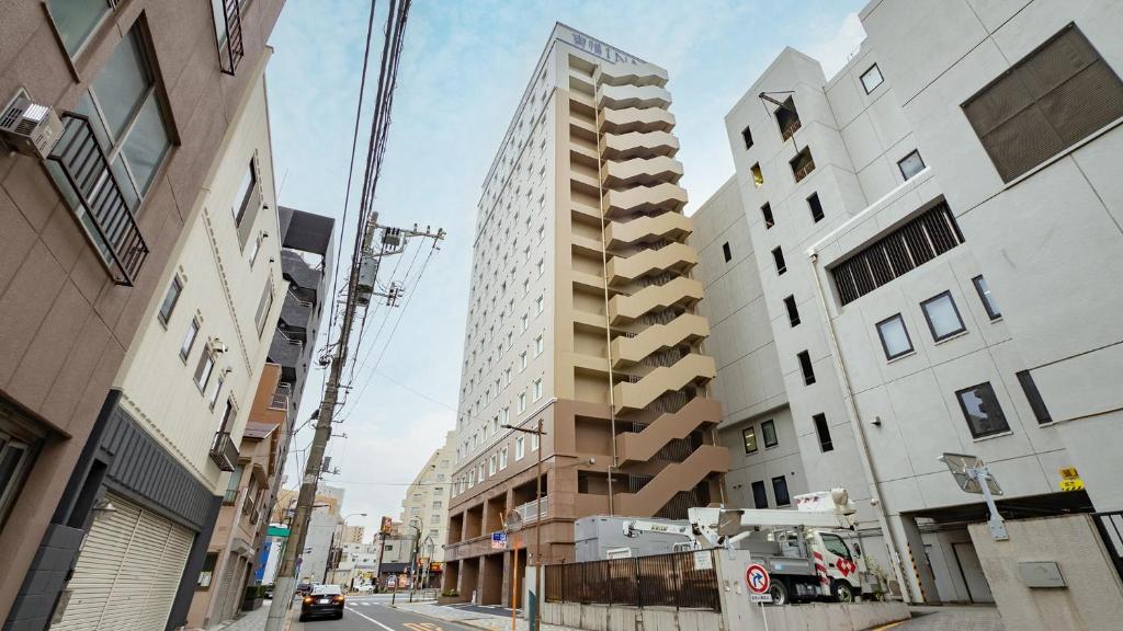 a tall building with balconies on a city street at Toyoko Inn Tokyo Minowa-eki in Tokyo