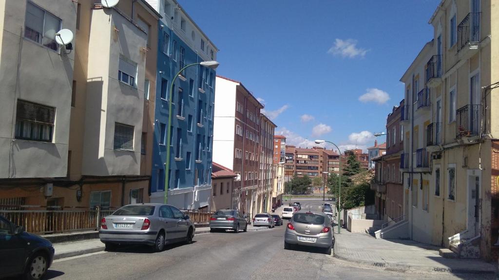 una calle de la ciudad con coches aparcados en la carretera en Apartamento Los Colonia, en Burgos