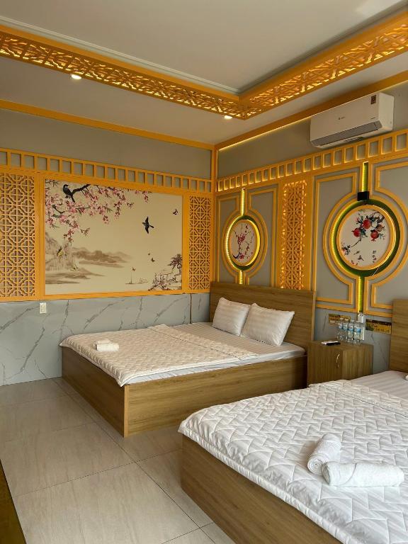 a bedroom with two beds and clocks on the wall at Khách sạn Phúc Đạt - Rạch Giá Phúc Đạt Hotel in Ấp Rạch Mẹo