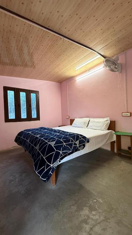 ein Schlafzimmer mit einem großen Bett in einem Zimmer in der Unterkunft Nature village resort in Rishikesh