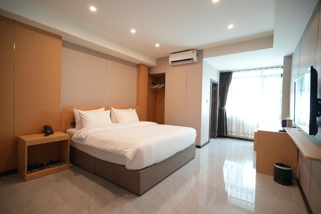 Ένα ή περισσότερα κρεβάτια σε δωμάτιο στο VELIN Pattaya Hotel