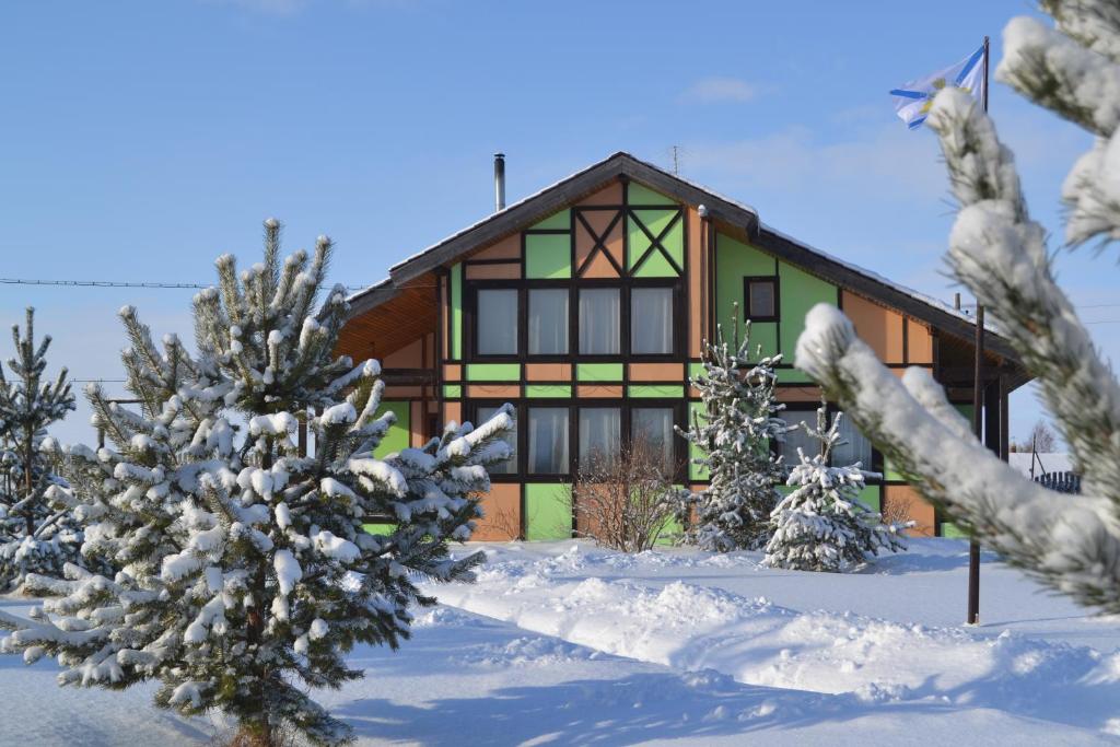 una casa en la nieve con árboles delante en Hotel Complex Ostrov, en Klimont'yevskaya