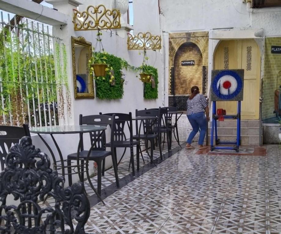 une femme qui traverse une pièce avec des tables et des chaises dans l'établissement Del Mar Residence, à Suizo