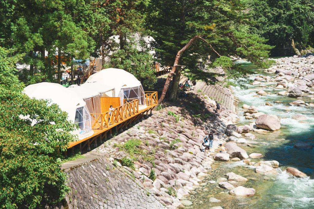 a gazebo on a bridge over a river at リバーサイドグランピングNuts in Higashiomi