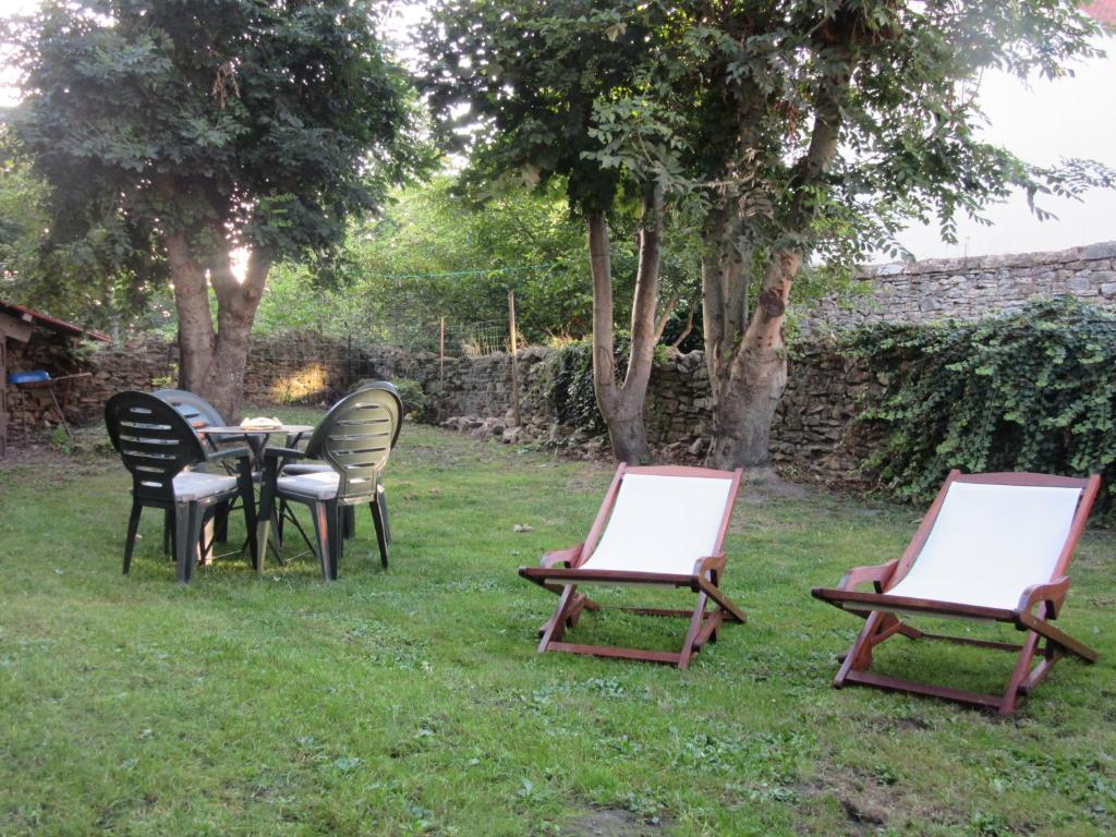 tres sillas y una mesa en el césped en p'tite maison entre mer et campagne, en Wimille
