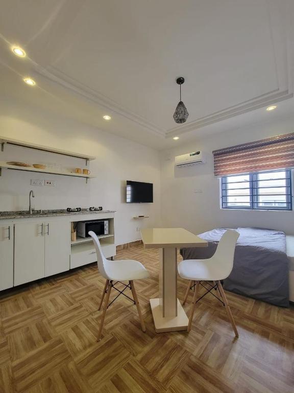 a room with a table and two chairs and a bed at Lovely self contained unit in a secure estate in Abuja