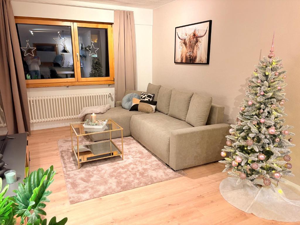 a living room with a christmas tree and a couch at Ambiente Appartement C2 - moderne Ferienwohnung mit Terrasse in Leukerbad in Leukerbad