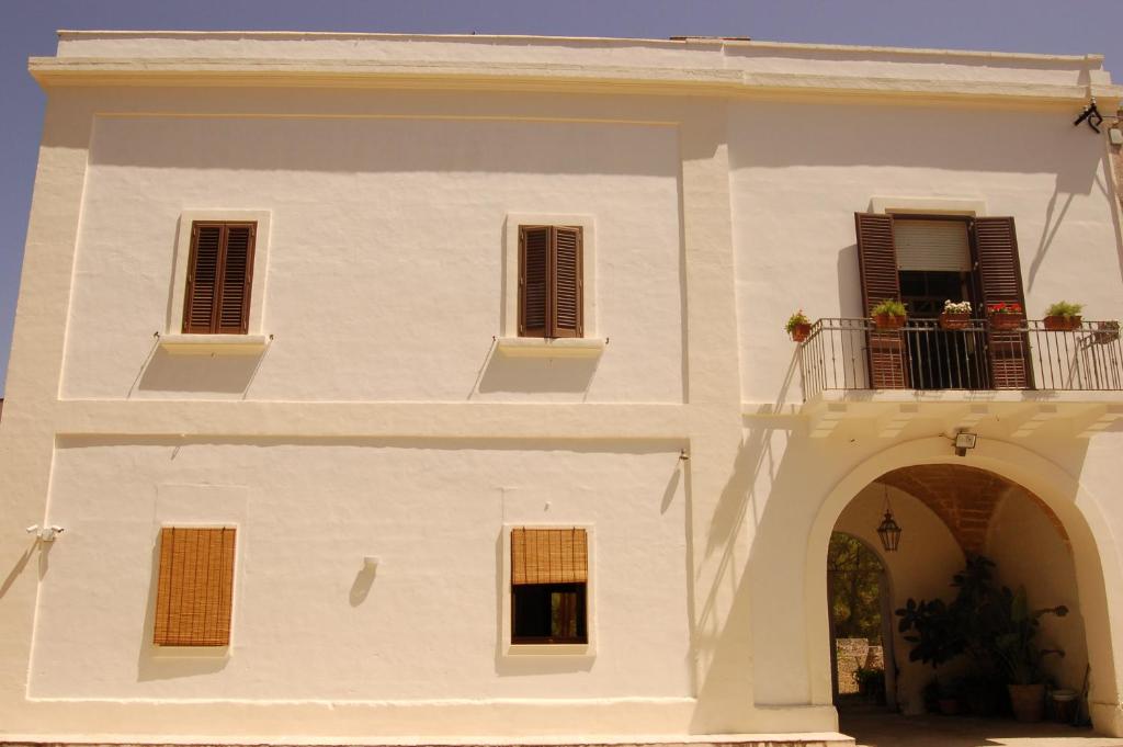 un edificio bianco con balcone e arco di Masseria Convento a Novoli