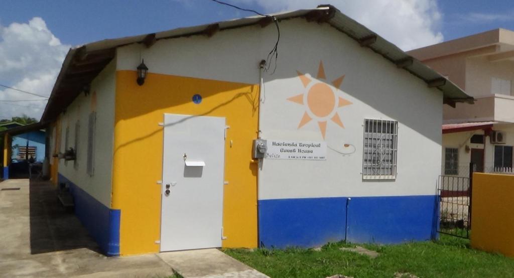 a building with a yellow and blue at Hacienda Tropical Guest House in Belmopan