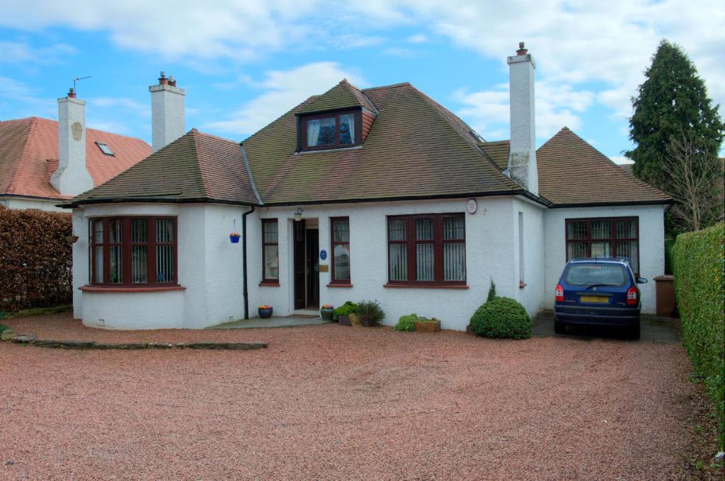 a white house with a car parked in front of it at Acer Lodge Guest House in Edinburgh