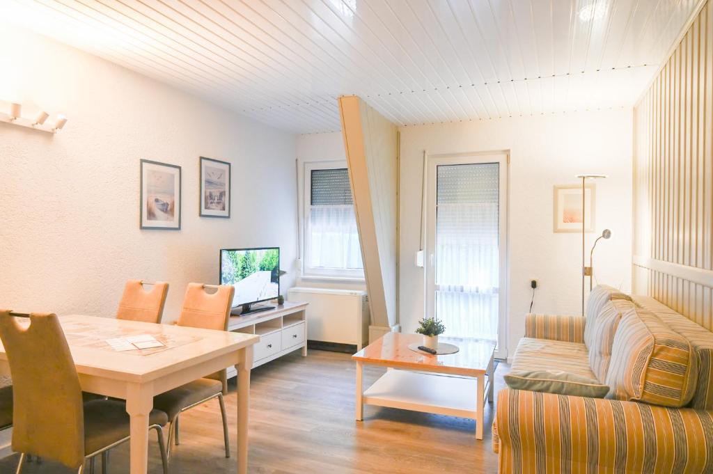 a living room with a table and a couch at Dünenhaus Fewos - Zum Strand 50m in Ueckeritz