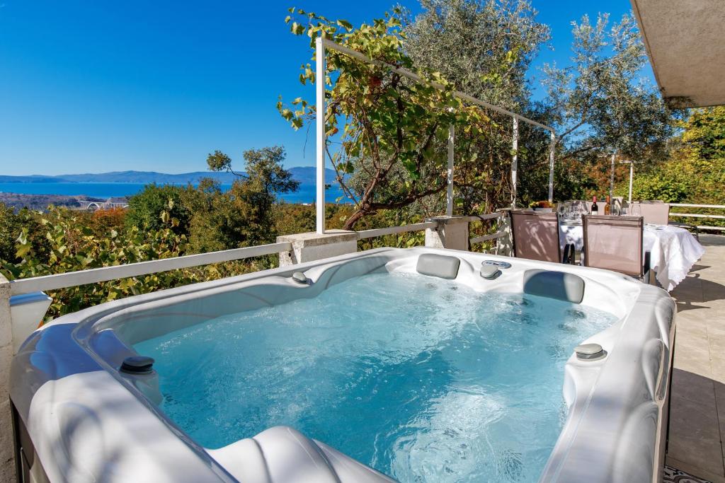 a hot tub sitting on top of a patio at Apartment Paris with jacuzzi and sea view in Šmrika