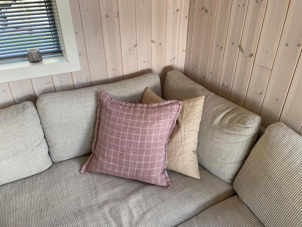 un sofá con almohadas sentado en una habitación en Cabin on hardangerfjord, 