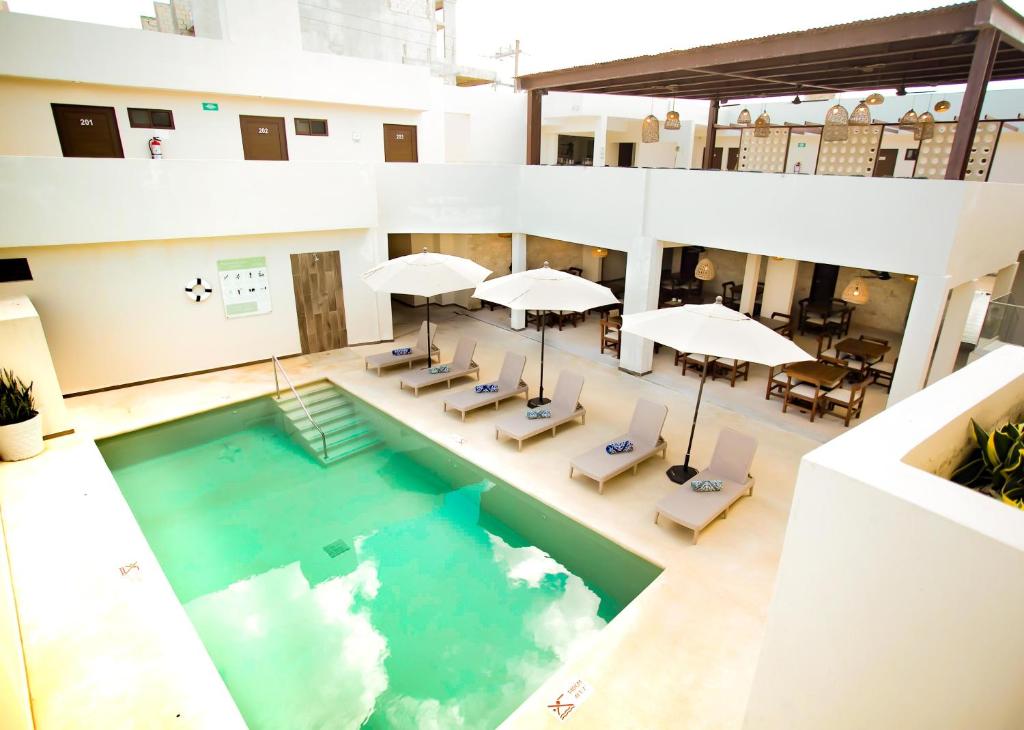 an overhead view of a pool with chairs and umbrellas at Hotel Yuhome Telchac in Telchac Puerto