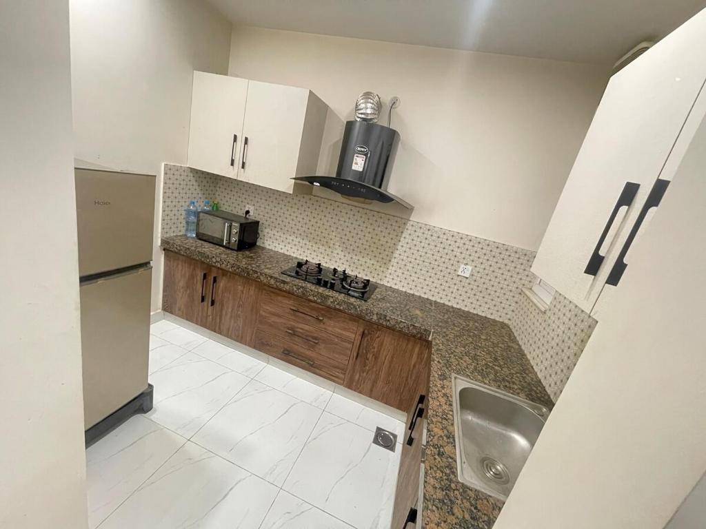 une petite cuisine avec un évier et un micro-ondes dans l'établissement Lower canal 1 BHK secure area, à Faisalabad