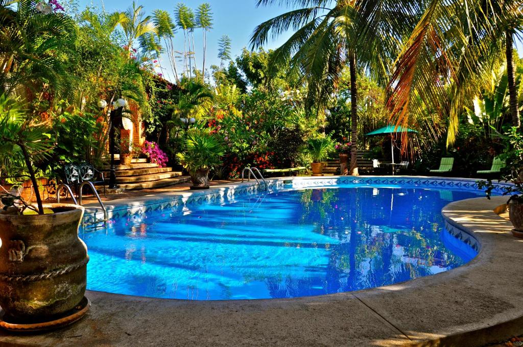 a swimming pool with blue water in a resort at Suites La Hacienda in Puerto Escondido