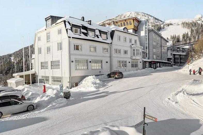 a large white building on a snow covered street at Tott vacation homes in Åre