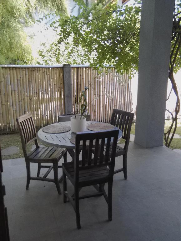 a patio table and chairs with a plant on it at Ju'Blu Hotel in Lovina