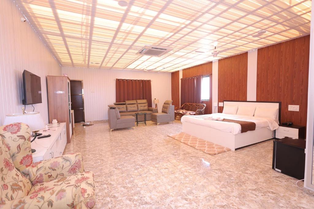 Mango Valley Resort Ganpatipule في راتنجاري: غرفة نوم مع سرير وغرفة معيشة