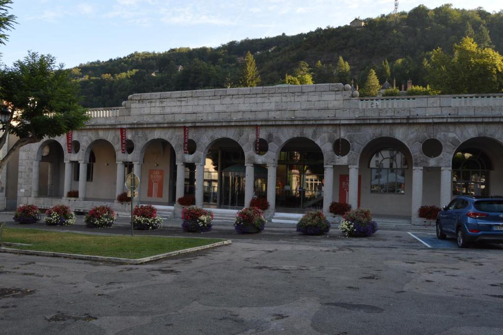 a building with a bunch of flowers in a parking lot at Hôtel Restaurant Le Bellevue in Ax-les-Thermes
